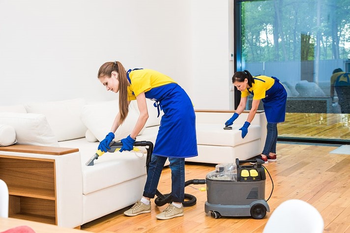 Professional home cleaning team cleaning a living area